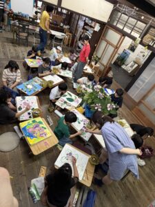 京都伏見の京町家の絵画教室子供アトリエ教室の様子。額アジサイを囲み子供たちが描いています